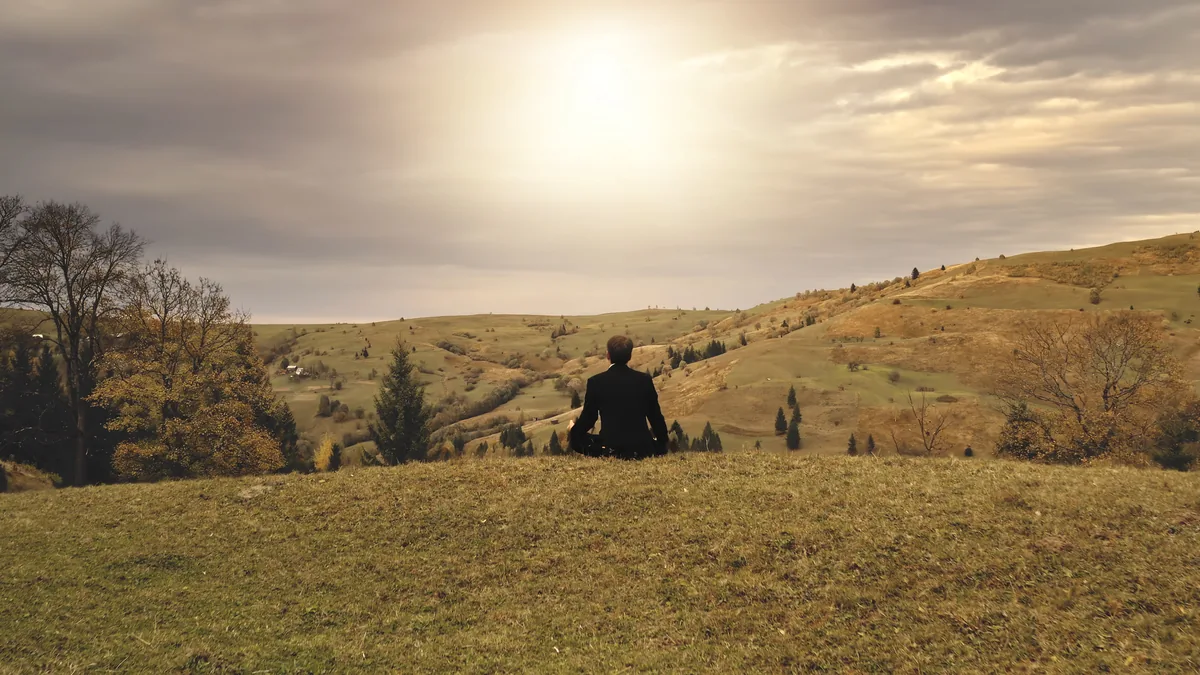 Personne assise face aux collines — ancrage et arrivée, stage Souffle & Silence dans le Lot