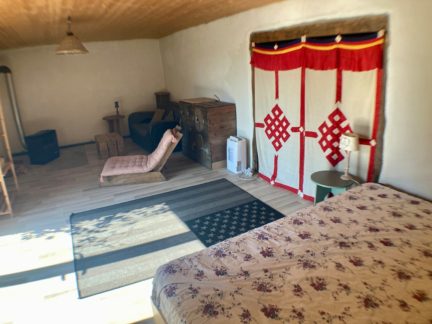Vue d’ensemble de la chambre nature à Gorses : lit, tenture et plafond bois