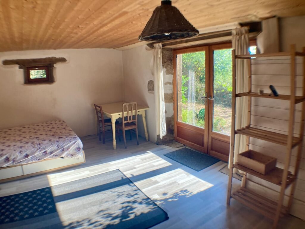 Chambre simple et authentique à Gorses dans le Lot, lit et porte-fenêtre sur le jardin